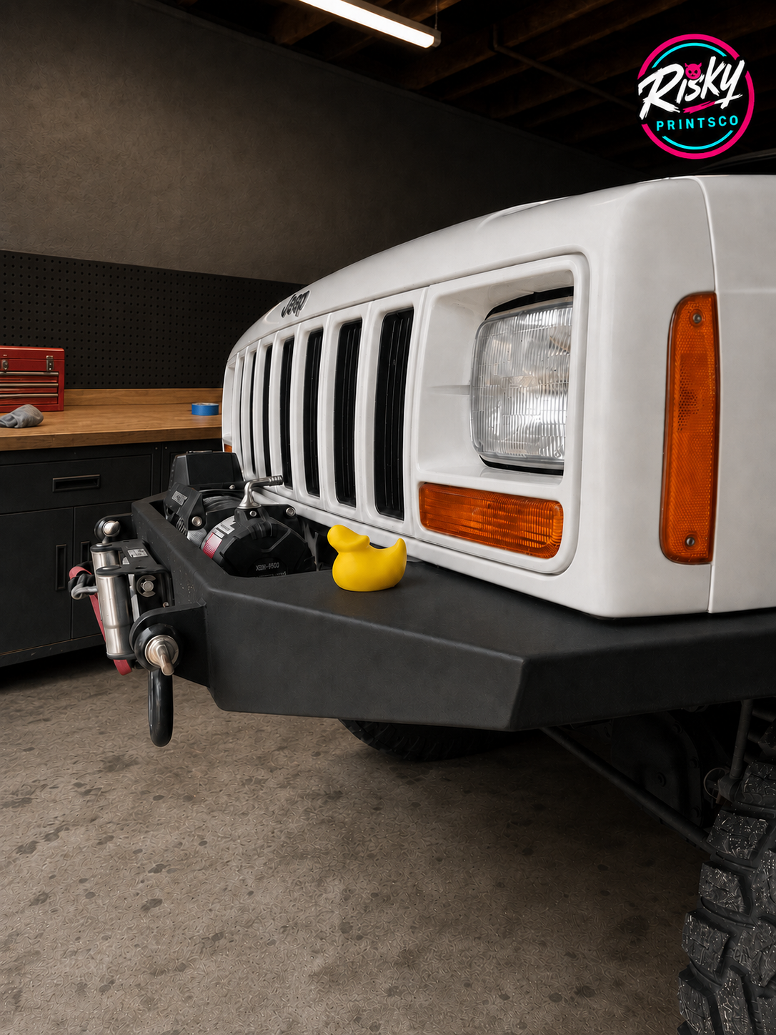 A bright yellow novelty duck displayed on the bumper of a white Jeep in a garage
